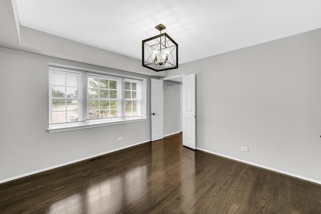 unfurnished dining area with dark hardwood / wood-style floors and a notable chandelier