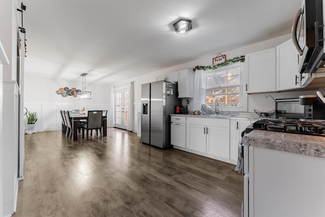 kitchen with stainless steel fridge, sink, decorative light fixtures, dark hardwood / wood-style floors, and white cabinetry