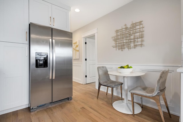 kitchen featuring white cabinetry, stainless steel fridge with ice dispenser, and light hardwood / wood-style flooring