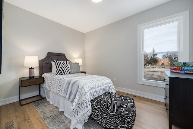 bedroom featuring light hardwood / wood-style flooring and multiple windows