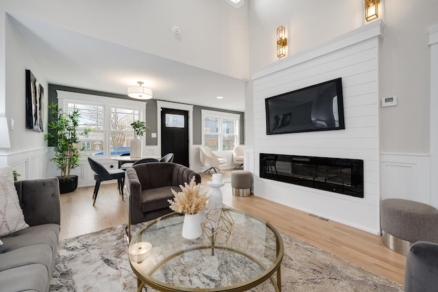 living room with a large fireplace and wood-type flooring