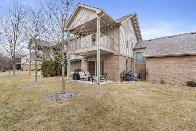 back of property with a balcony, a yard, and a patio