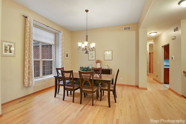 dining area featuring an inviting chandelier and light hardwood / wood-style flooring