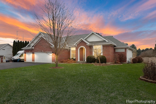 view of front of home with a yard and a garage