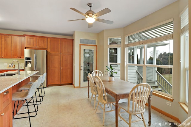 dining space with ceiling fan and sink