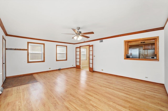 empty room featuring light hardwood / wood-style floors, ceiling fan, and ornamental molding