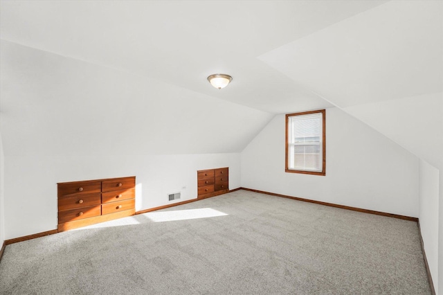 additional living space featuring carpet and vaulted ceiling