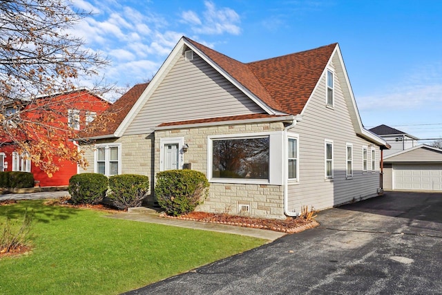 view of front facade with a garage, a front lawn, and an outdoor structure