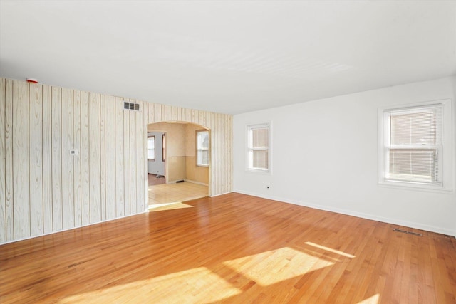 empty room with hardwood / wood-style floors and wood walls