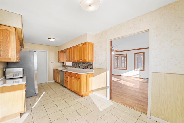 kitchen with stainless steel dishwasher, decorative backsplash, light tile patterned floors, and sink