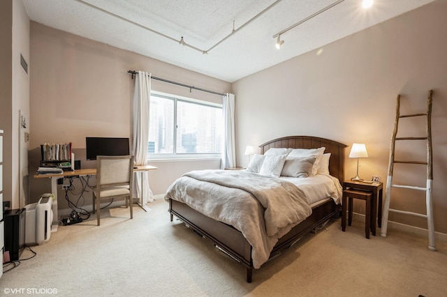 bedroom with light carpet and a textured ceiling