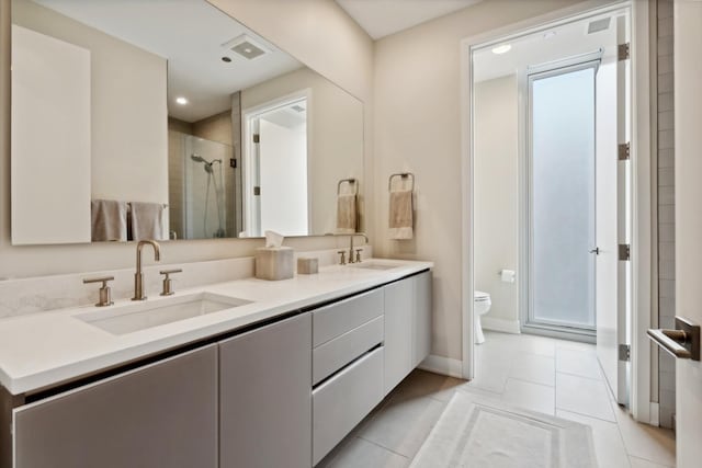 bathroom with a shower with door, tile patterned floors, vanity, and toilet