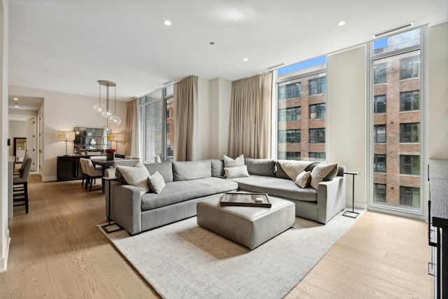 living room with floor to ceiling windows and light wood-type flooring