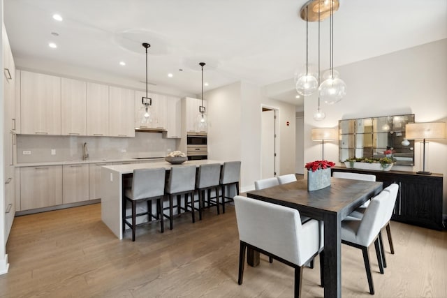 dining room with sink and light wood-type flooring