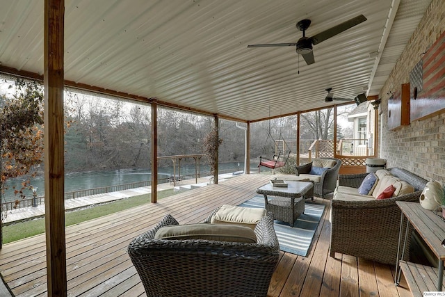 sunroom featuring a water view and ceiling fan