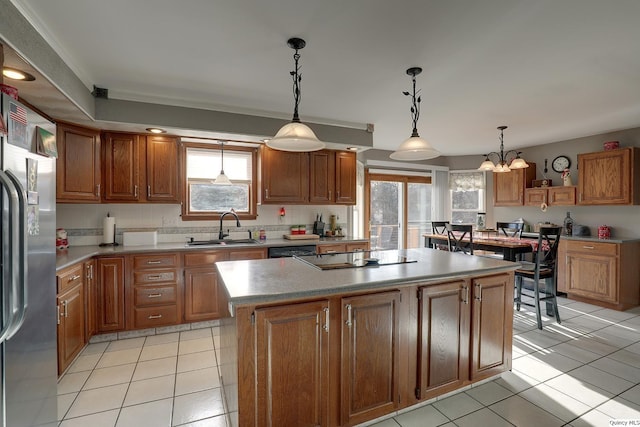 kitchen featuring decorative light fixtures, sink, a kitchen island, and black appliances