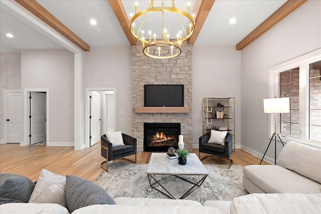 living room with beam ceiling, a fireplace, and light hardwood / wood-style floors