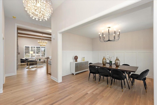 dining area featuring a notable chandelier, beam ceiling, and light hardwood / wood-style flooring