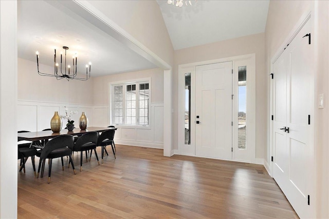 foyer featuring vaulted ceiling, a chandelier, and light hardwood / wood-style floors