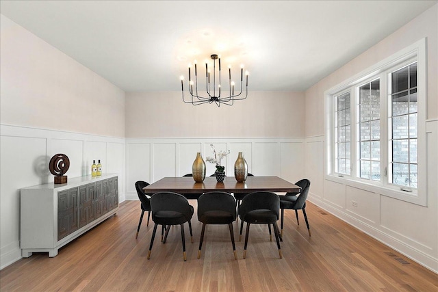 dining area with hardwood / wood-style flooring and a notable chandelier