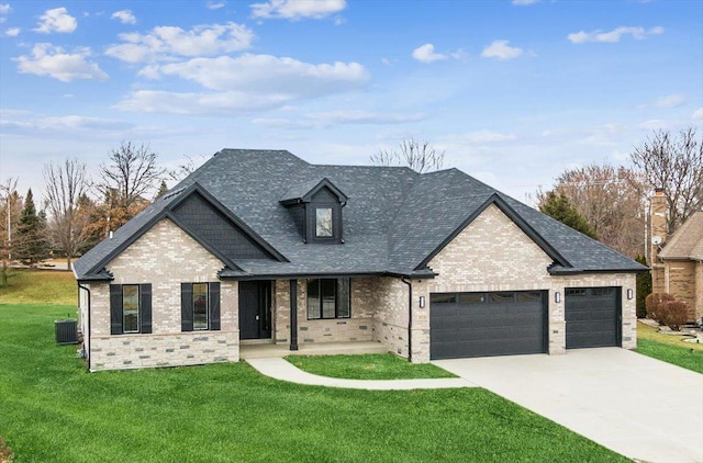 view of front facade with a garage, central AC, and a front lawn