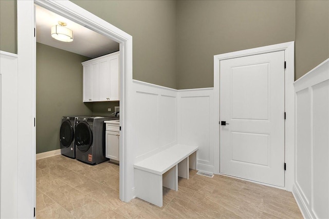 washroom with washing machine and dryer and cabinets