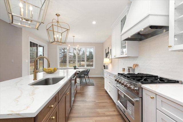 kitchen featuring high end stainless steel range oven, custom exhaust hood, and white cabinetry