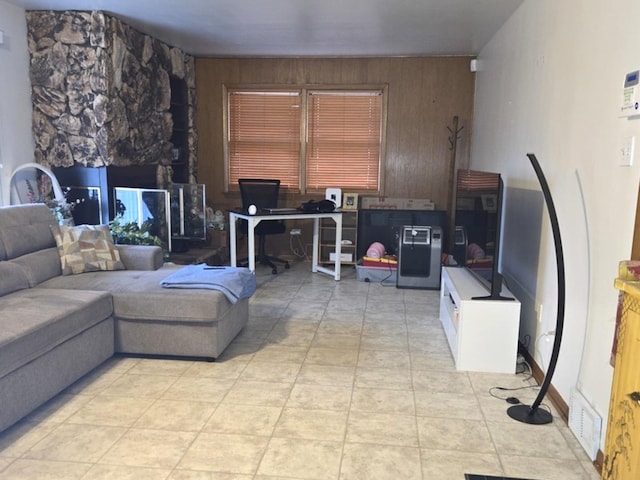 living room featuring light tile patterned floors and wooden walls