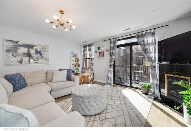 living room featuring a tile fireplace and a chandelier