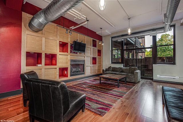 living room with hardwood / wood-style flooring and a tiled fireplace