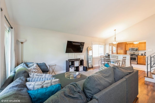 living room with light hardwood / wood-style floors and vaulted ceiling