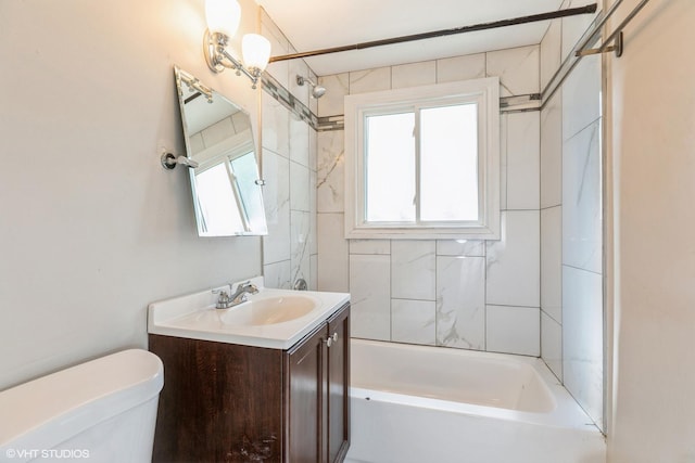 full bathroom featuring tiled shower / bath, vanity, and toilet