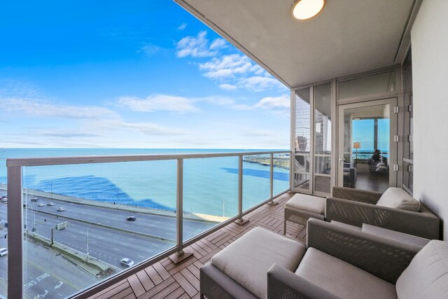 balcony with outdoor lounge area and a water view