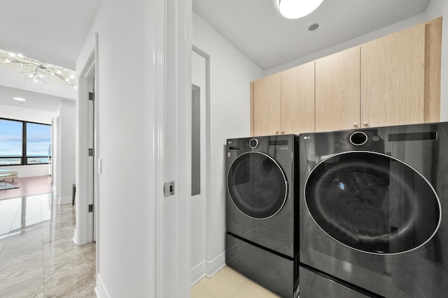 laundry room with separate washer and dryer and cabinets