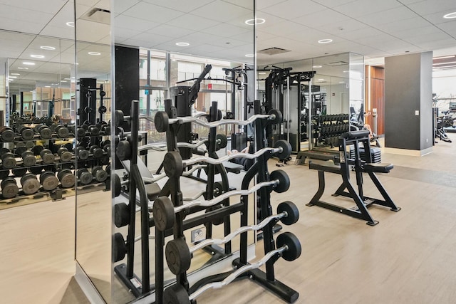 gym featuring a paneled ceiling and light hardwood / wood-style floors