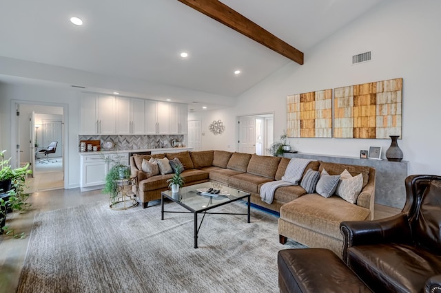 living room with beamed ceiling and high vaulted ceiling