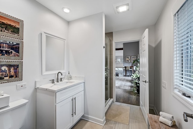 bathroom with vanity, toilet, and walk in shower