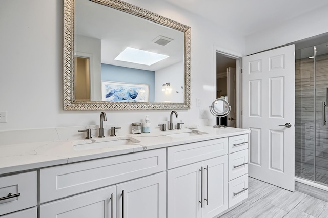 bathroom with a skylight, vanity, and a shower with shower door