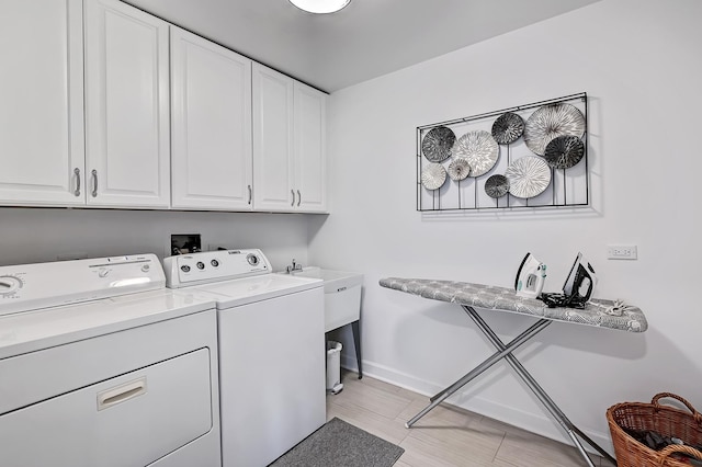 washroom featuring washing machine and dryer and cabinets