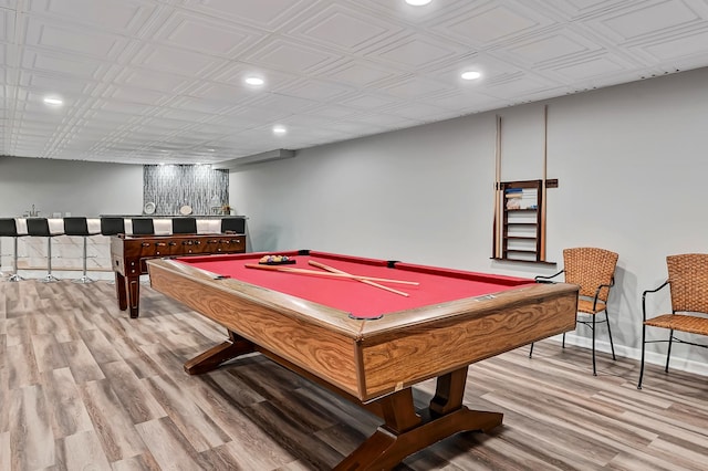 game room featuring light hardwood / wood-style floors, billiards, and indoor bar