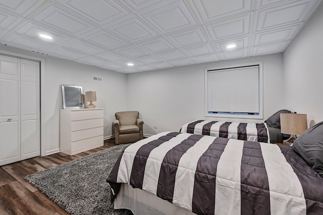 bedroom with dark hardwood / wood-style flooring and a closet