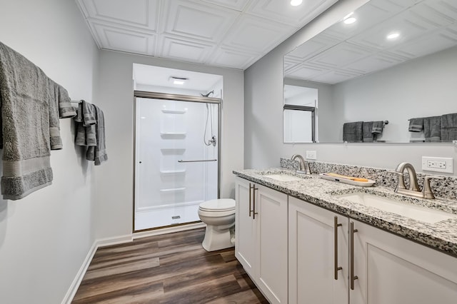 bathroom with wood-type flooring, vanity, toilet, and a shower with door