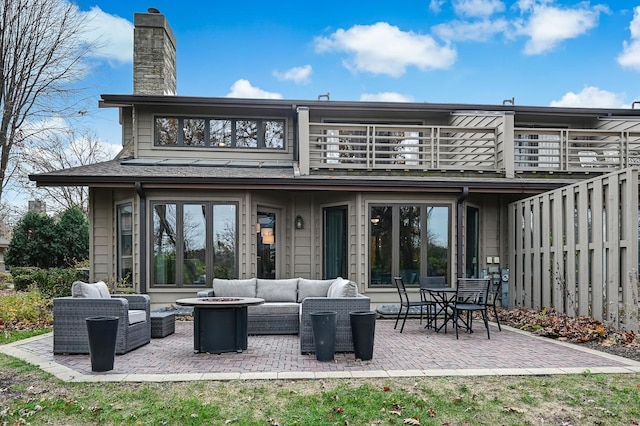 rear view of house with an outdoor living space, a balcony, and a patio area