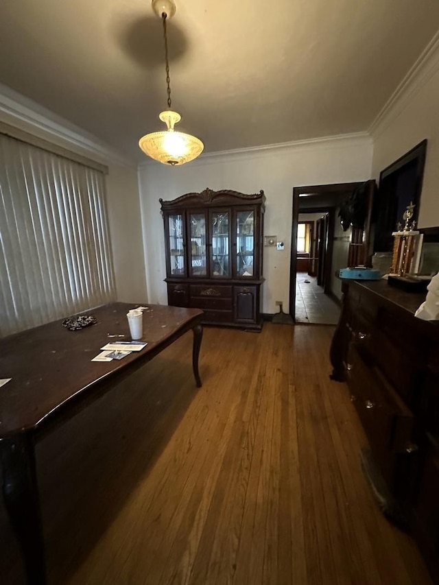 dining space featuring hardwood / wood-style flooring and crown molding