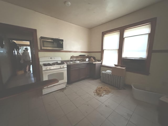 kitchen with radiator heating unit and white gas range oven