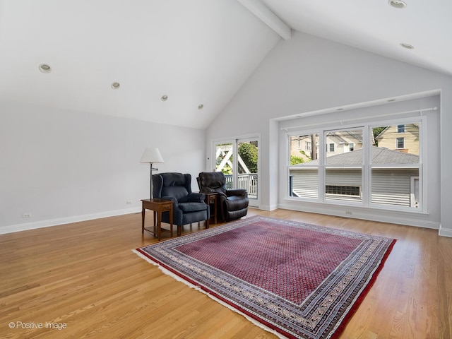 living room featuring beam ceiling, high vaulted ceiling, and wood-type flooring