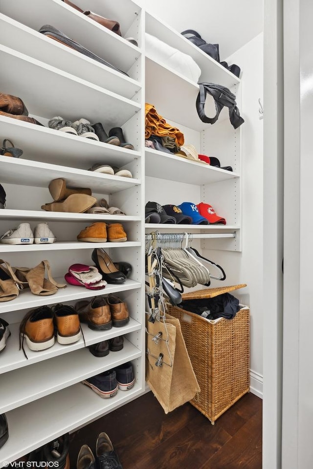 walk in closet with dark wood-type flooring