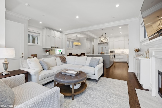 living room with crown molding, hardwood / wood-style floors, and a high end fireplace