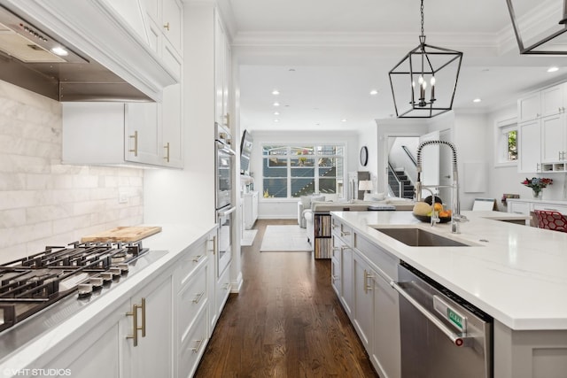 kitchen featuring appliances with stainless steel finishes, custom exhaust hood, a kitchen island with sink, sink, and white cabinetry