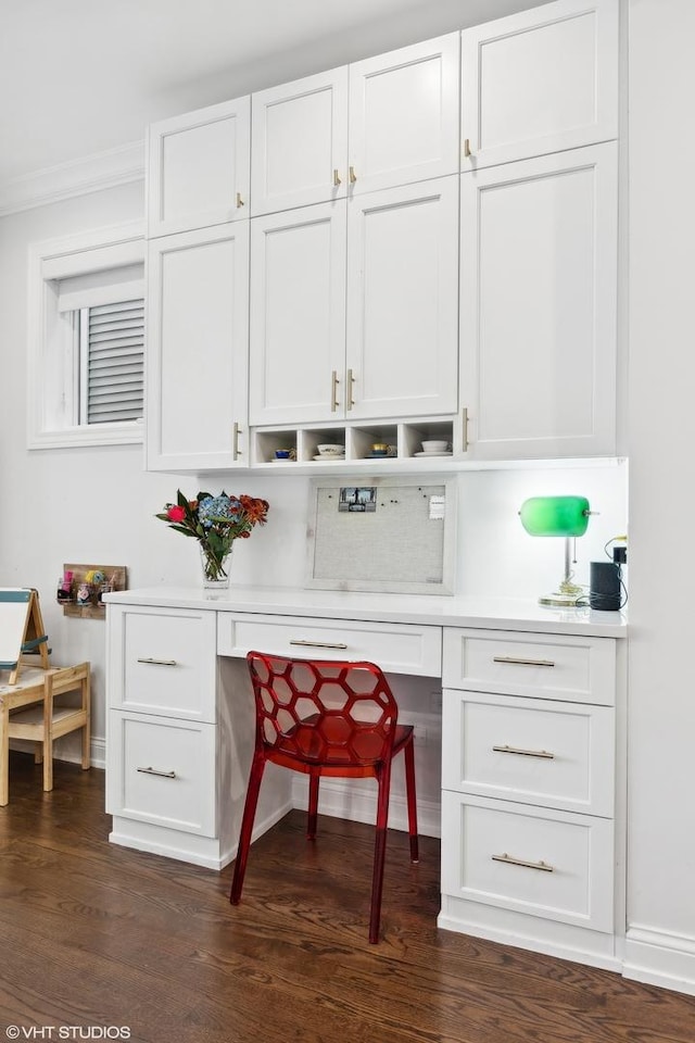 bar with white cabinetry, dark hardwood / wood-style flooring, built in desk, and ornamental molding